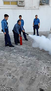 Firemen explain how to use fire extinguishers to the participants. 1