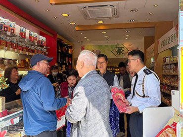 Members of the Tai Po District Fight Crime Committee distribute crime prevention souvenirs to merchants. 3
